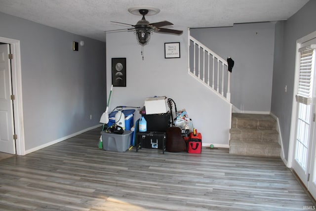 living room featuring a textured ceiling, wood-type flooring, plenty of natural light, and ceiling fan