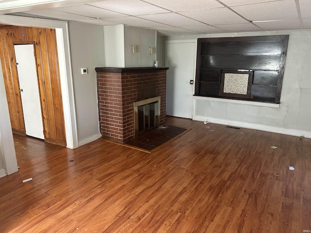 unfurnished living room with a paneled ceiling, a fireplace, and hardwood / wood-style floors