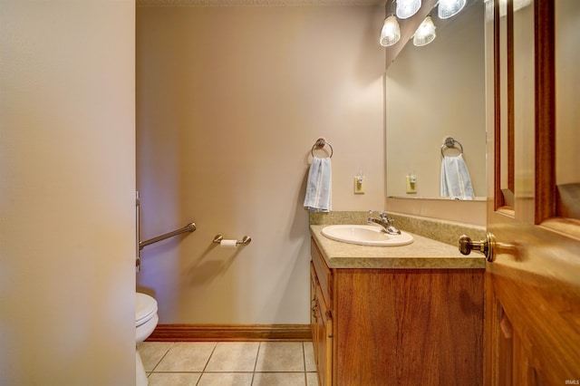 bathroom with toilet, vanity, and tile patterned flooring