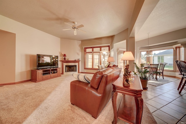 tiled living room with a textured ceiling and ceiling fan with notable chandelier