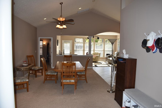 dining area with arched walkways, ceiling fan, vaulted ceiling, and visible vents