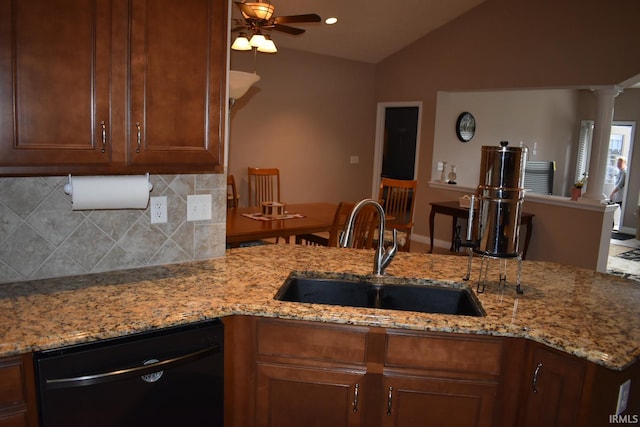 kitchen with lofted ceiling, light stone counters, a sink, black dishwasher, and backsplash