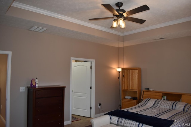 carpeted bedroom featuring ornamental molding, a raised ceiling, and visible vents