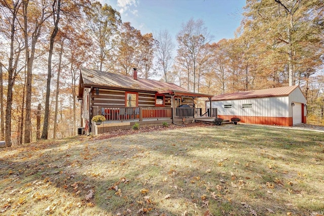 exterior space with a yard, an outdoor structure, a garage, and a deck