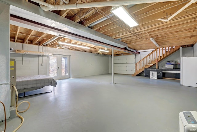 basement featuring french doors and white fridge