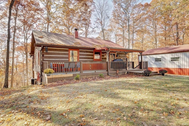 view of front facade with a front lawn, central AC, and a wooden deck