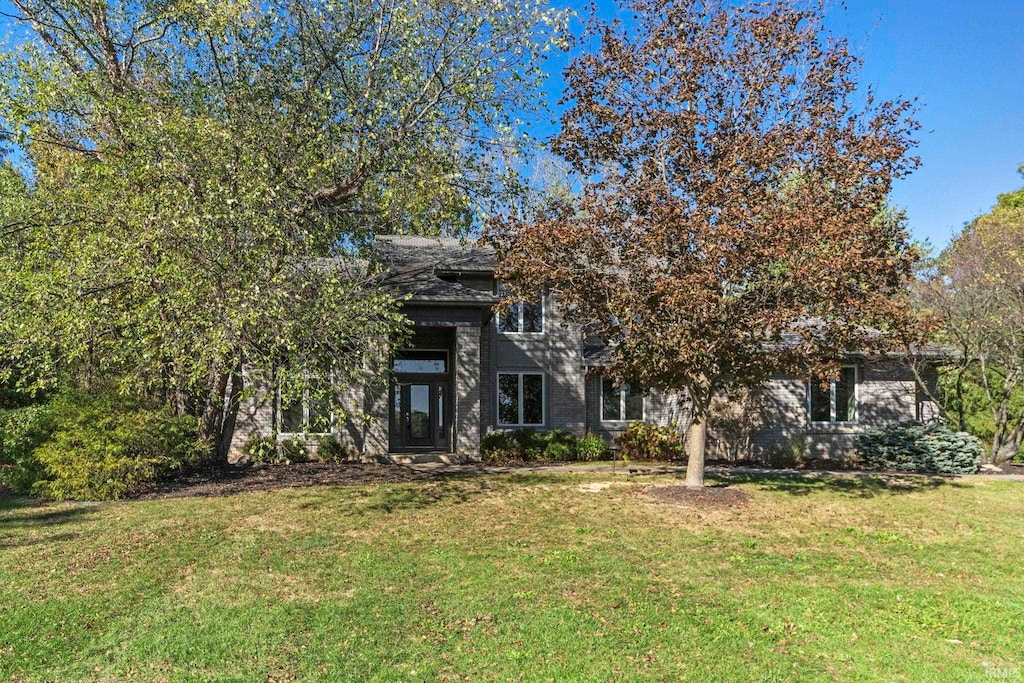 view of property hidden behind natural elements featuring a front yard