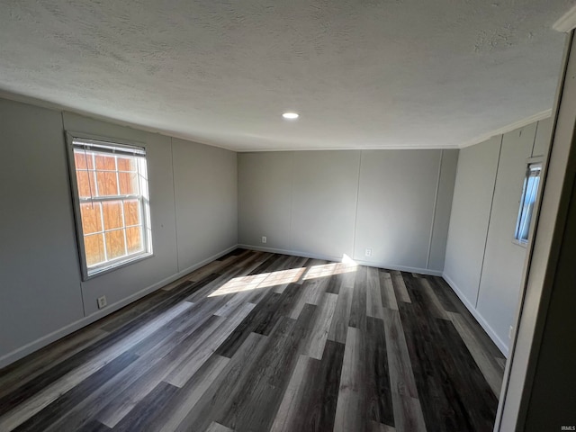 unfurnished room with crown molding, dark hardwood / wood-style floors, and a textured ceiling