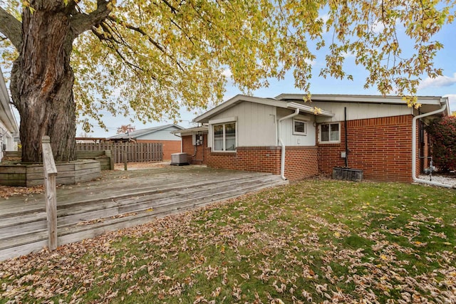 back of house with central AC unit, a yard, and a deck