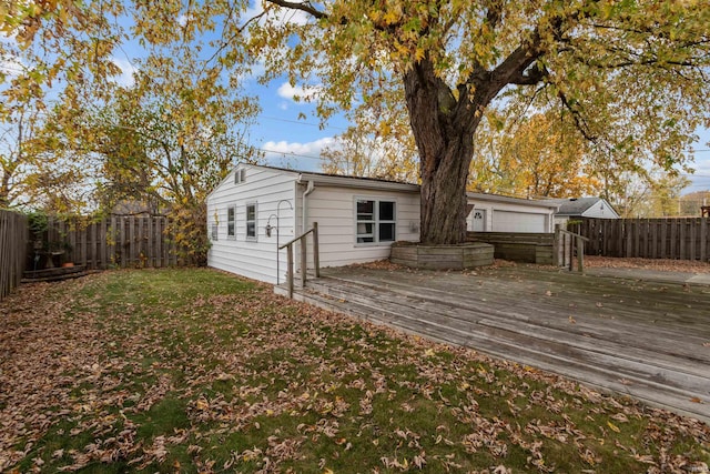 rear view of property featuring a deck and a lawn