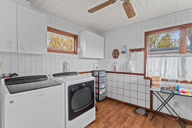 laundry room featuring cabinets, washer and clothes dryer, light hardwood / wood-style flooring, and a wealth of natural light