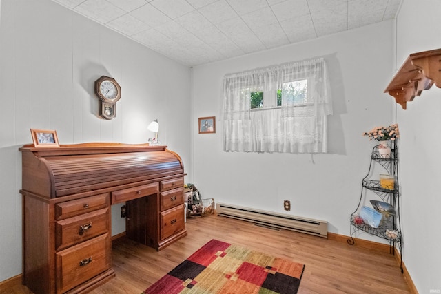 home office with baseboard heating and light hardwood / wood-style flooring