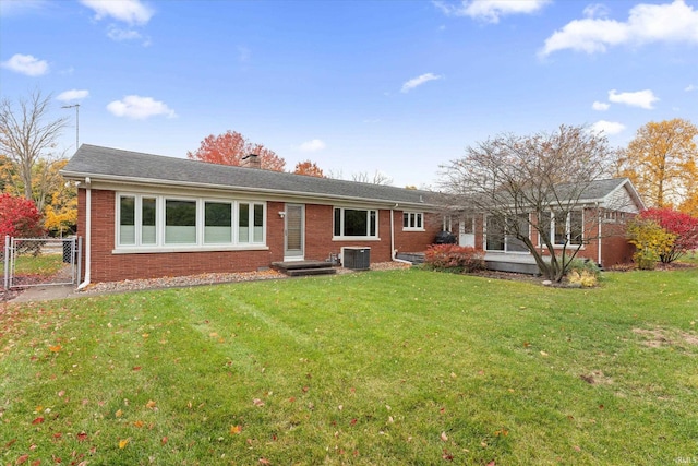 view of front of home with a front yard and central AC