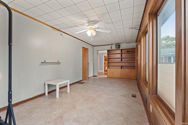 tiled spare room with crown molding and ceiling fan