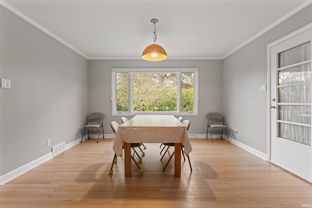 dining space featuring light hardwood / wood-style flooring and ornamental molding