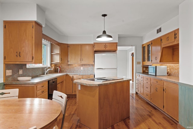 kitchen featuring decorative backsplash, a kitchen island, light hardwood / wood-style floors, decorative light fixtures, and white appliances