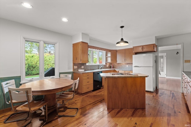 kitchen featuring decorative light fixtures, light wood-type flooring, plenty of natural light, and white refrigerator