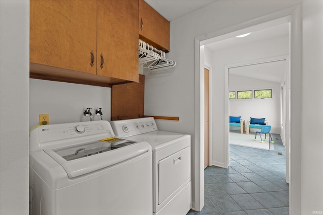 laundry area featuring independent washer and dryer, light tile patterned floors, and cabinets