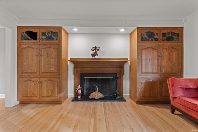 sitting room with light hardwood / wood-style floors and crown molding