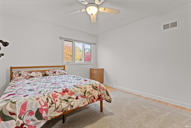 bedroom with ceiling fan, ornamental molding, and light hardwood / wood-style floors