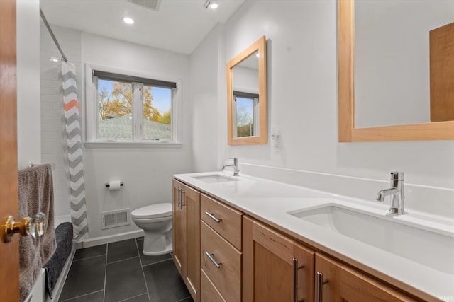 bathroom featuring vanity, toilet, a tile shower, and tile patterned flooring