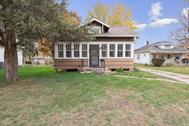 view of front of home featuring a sunroom and a front lawn