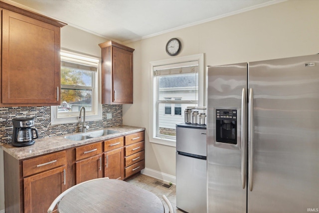 kitchen featuring ornamental molding, stainless steel fridge, sink, stainless steel fridge with ice dispenser, and tasteful backsplash