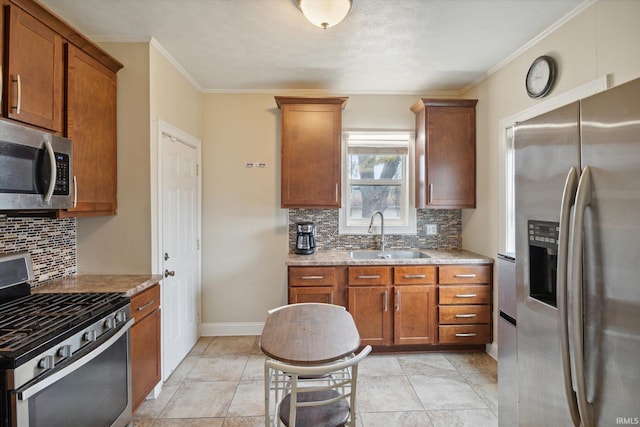 kitchen with light stone countertops, appliances with stainless steel finishes, sink, and decorative backsplash