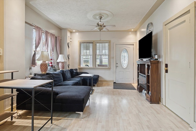 entryway with ceiling fan, a textured ceiling, light hardwood / wood-style floors, and plenty of natural light