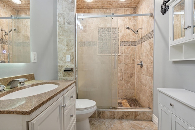 bathroom featuring vanity, toilet, and a shower with door