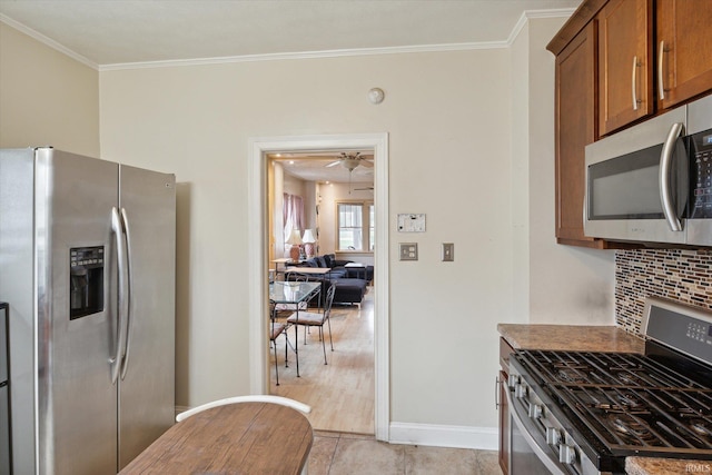 kitchen with backsplash, appliances with stainless steel finishes, ceiling fan, light hardwood / wood-style flooring, and crown molding