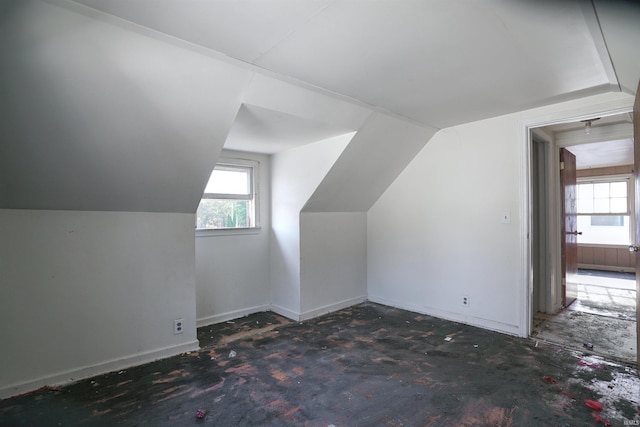 additional living space featuring lofted ceiling and plenty of natural light