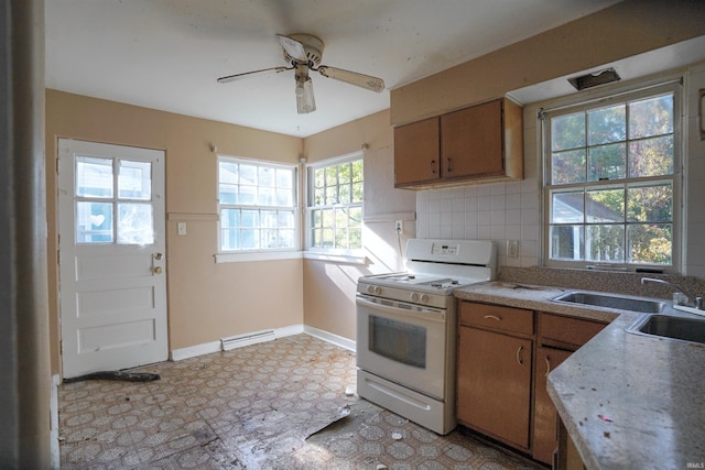 kitchen featuring sink, decorative backsplash, ceiling fan, and gas range gas stove