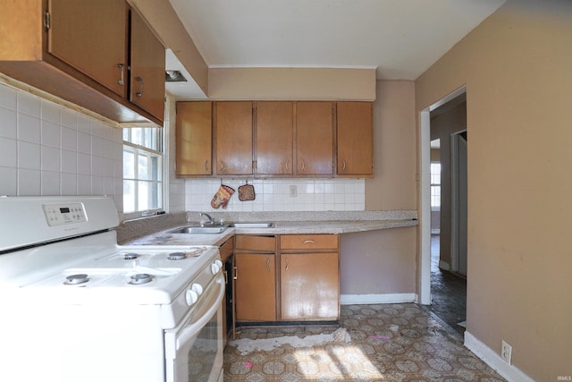 kitchen featuring tasteful backsplash, sink, and white stove