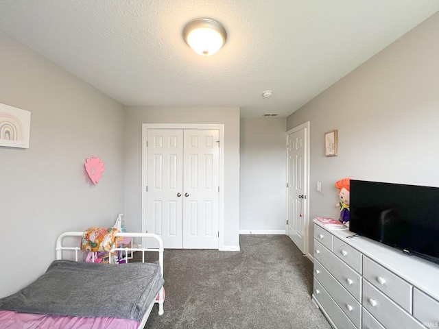 carpeted bedroom with a closet and a textured ceiling