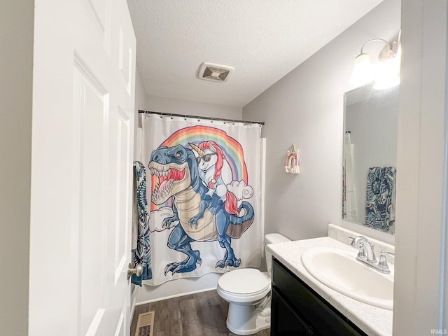 full bathroom with wood-type flooring, a textured ceiling, toilet, vanity, and shower / tub combo with curtain