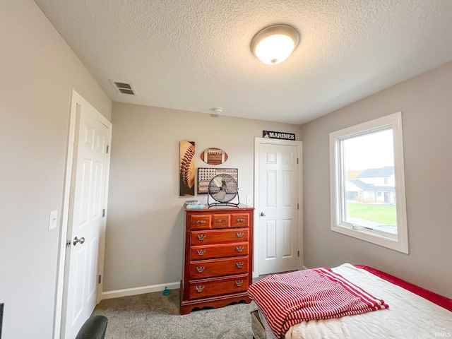 carpeted bedroom with a textured ceiling