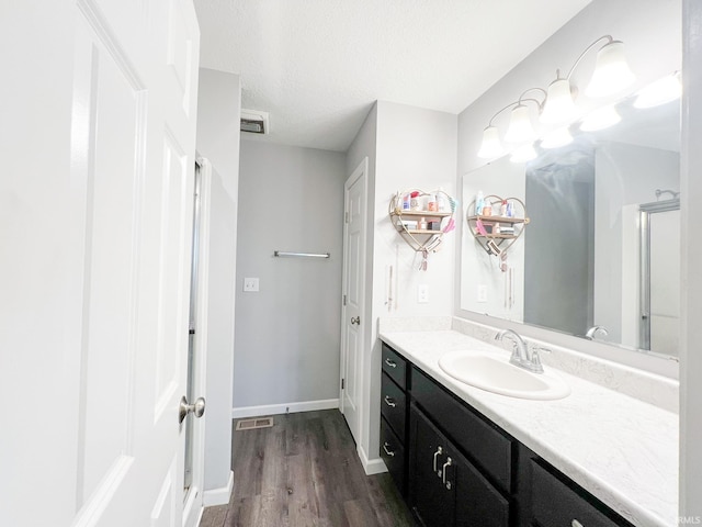 bathroom with vanity, hardwood / wood-style floors, and a textured ceiling