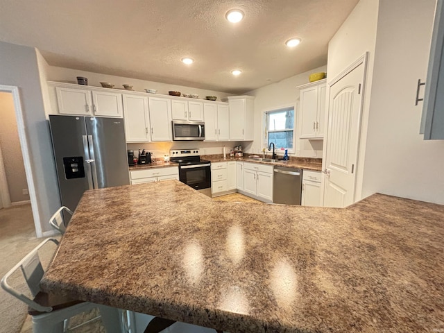 kitchen featuring sink, stainless steel appliances, a breakfast bar, and white cabinets