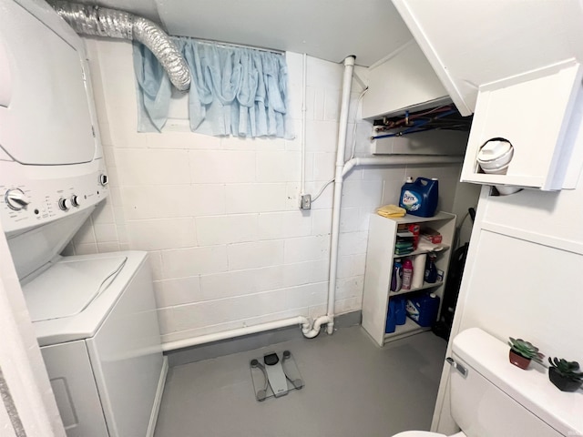 clothes washing area with stacked washer / dryer