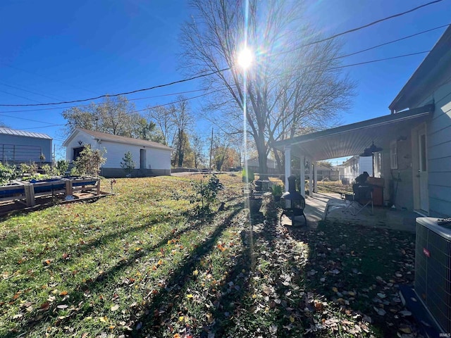 view of yard with a patio, central AC, and an outbuilding