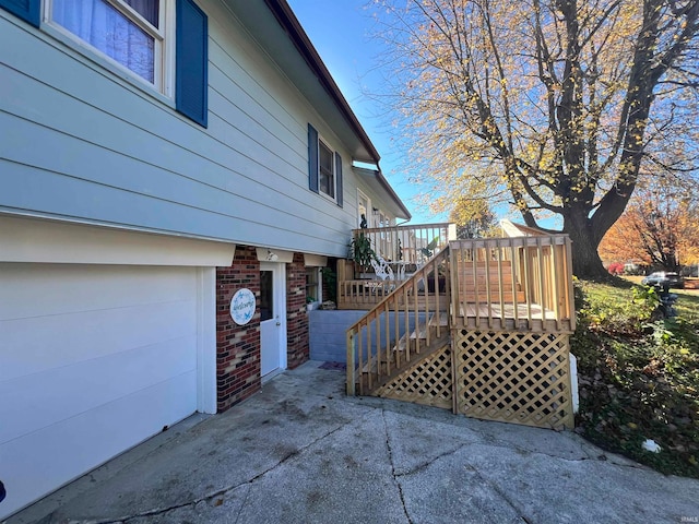 view of side of property featuring a wooden deck and a garage