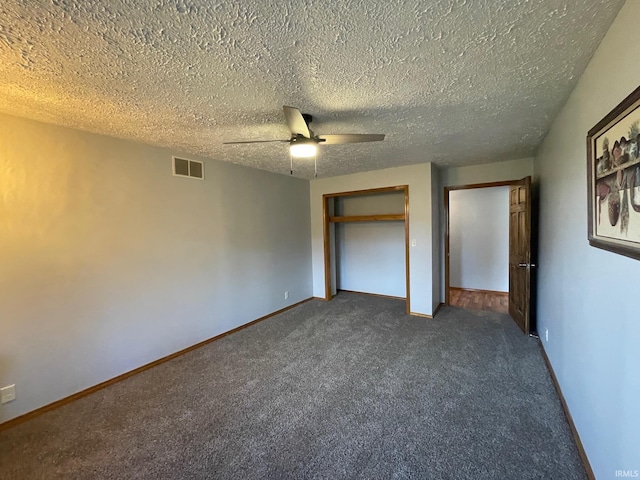 unfurnished bedroom with ceiling fan, a textured ceiling, and dark colored carpet