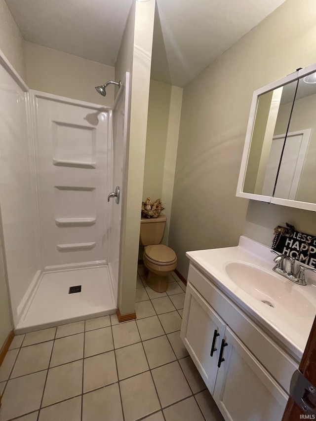 bathroom featuring vanity, toilet, a shower, and tile patterned floors