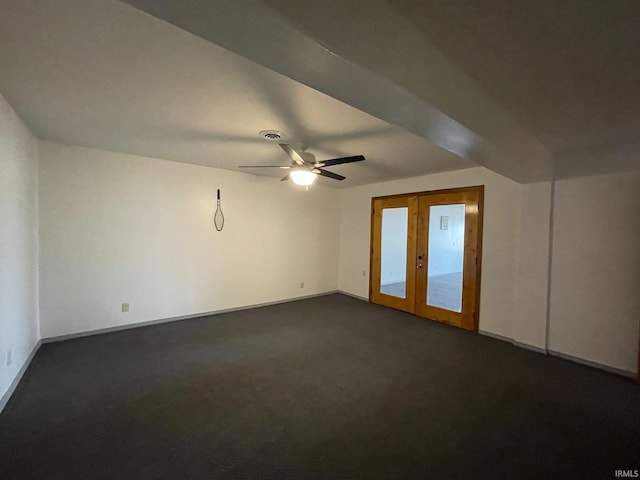 empty room with dark colored carpet, french doors, and ceiling fan