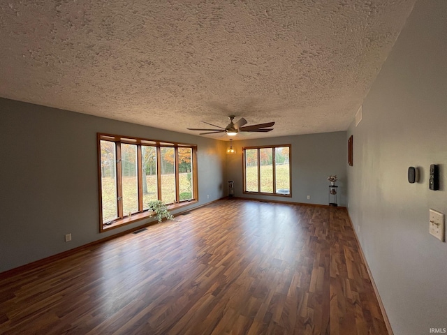 spare room featuring dark wood-type flooring, a textured ceiling, and ceiling fan