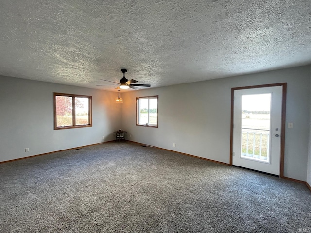 carpeted spare room featuring a textured ceiling and ceiling fan