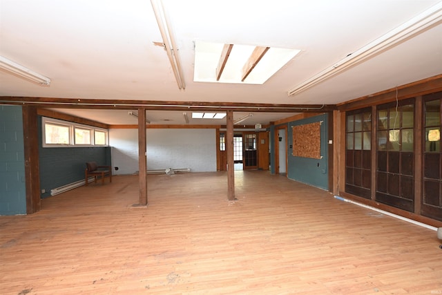 basement with baseboard heating and light wood-type flooring