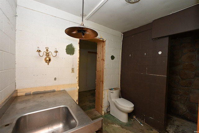 bathroom with concrete flooring and toilet