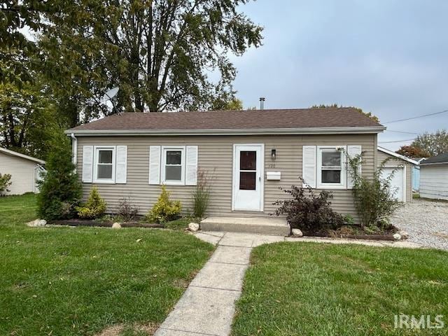 view of front of property with a front yard and a garage